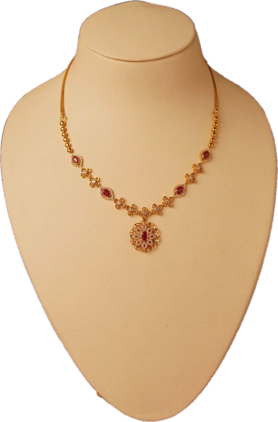 Gold necklace with ruby marquise links and a floral ruby pendant on a cream display bust